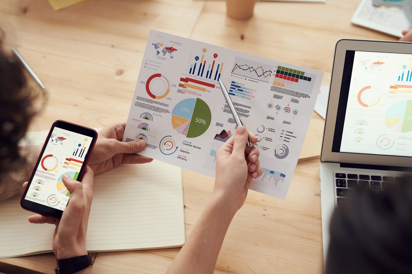 Marketer reviewing campaign analytics on paper and phone