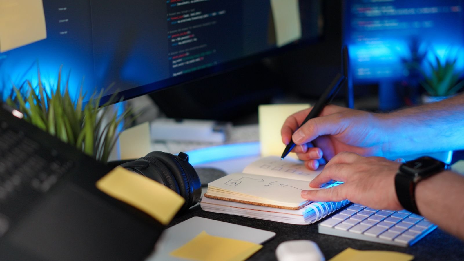 A developer checking code and taking notes