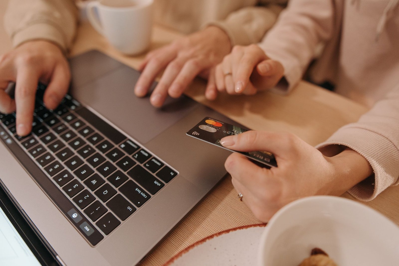 Two people at a laptop paying for an online order with a bank card