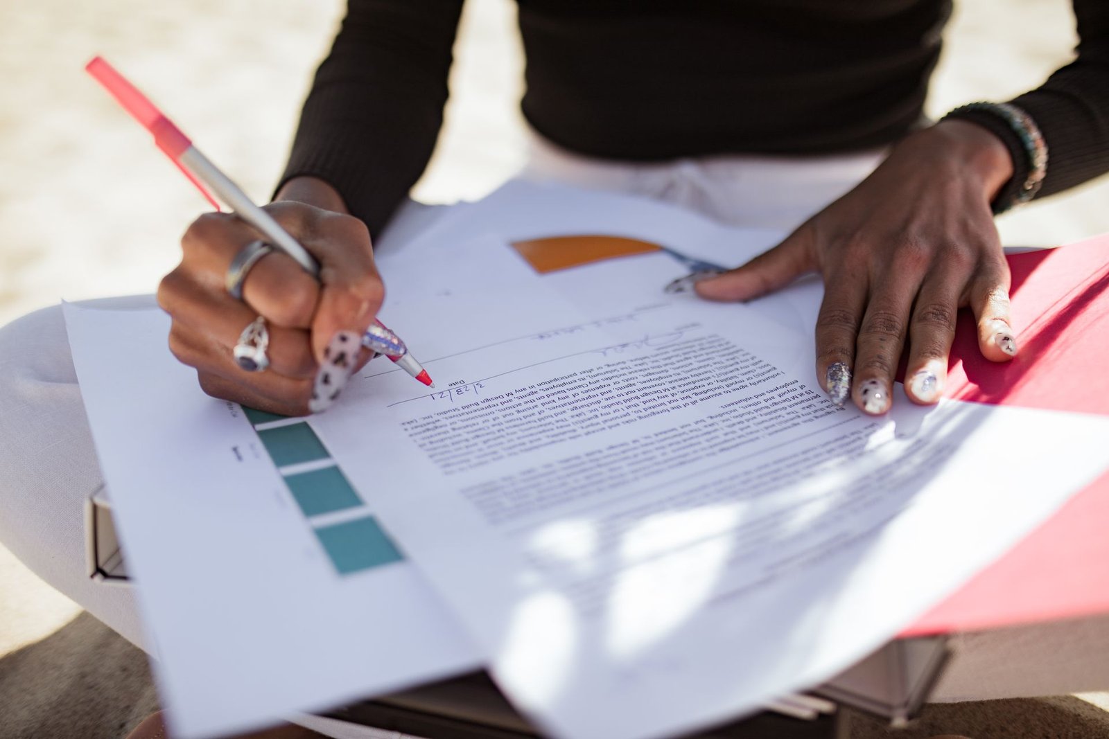 Two people checking a printed report together, one marking it with a pen