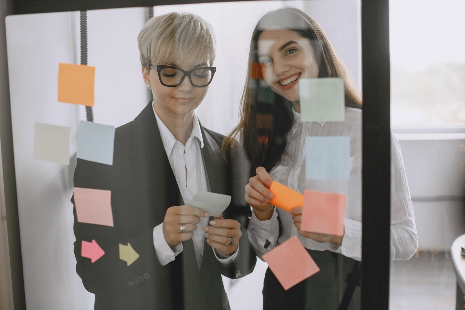 A small team planning a process with sticky notes on a wall