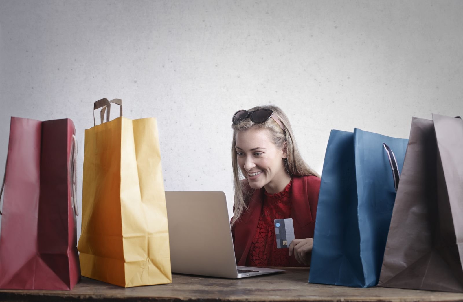 Shopper with bags buying online on a laptop