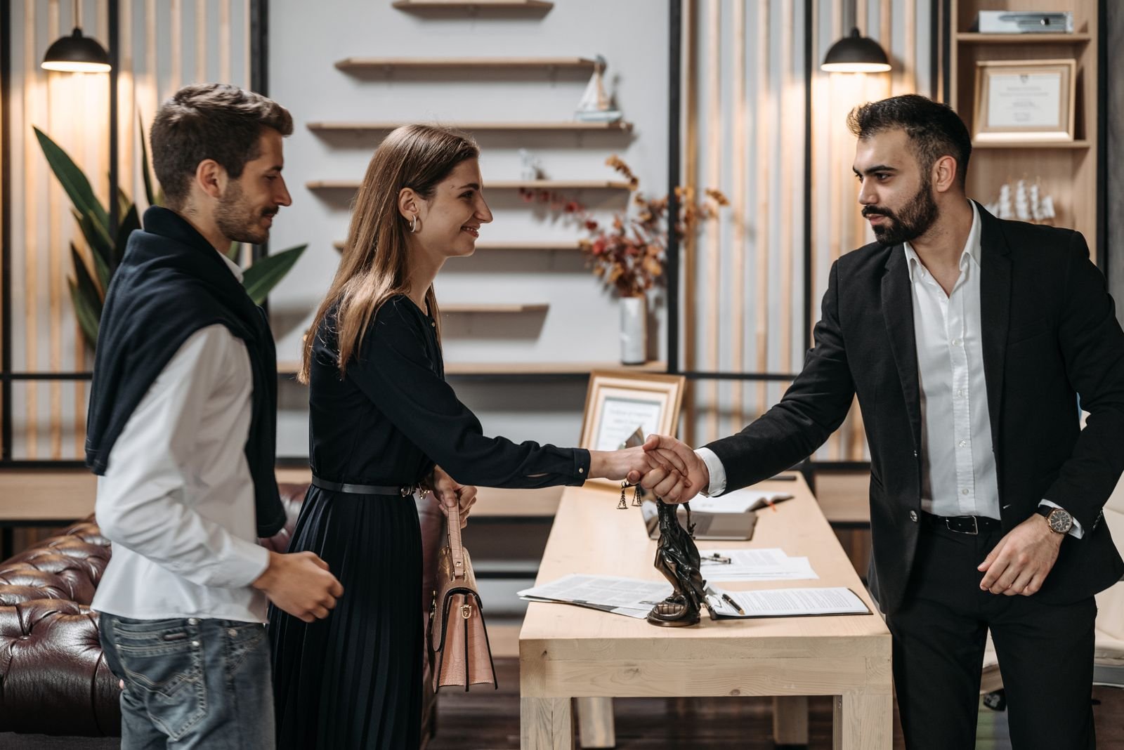 Two partners shaking hands across a desk