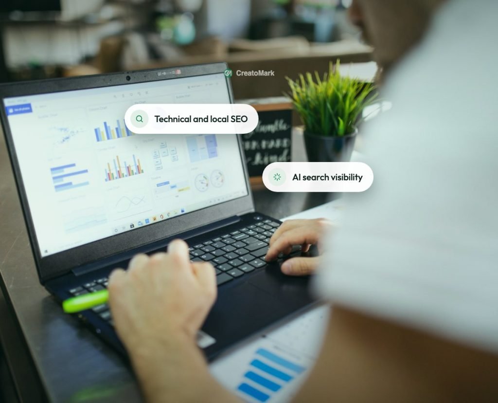 A marketer reviewing analytics charts on a laptop next to a green plant