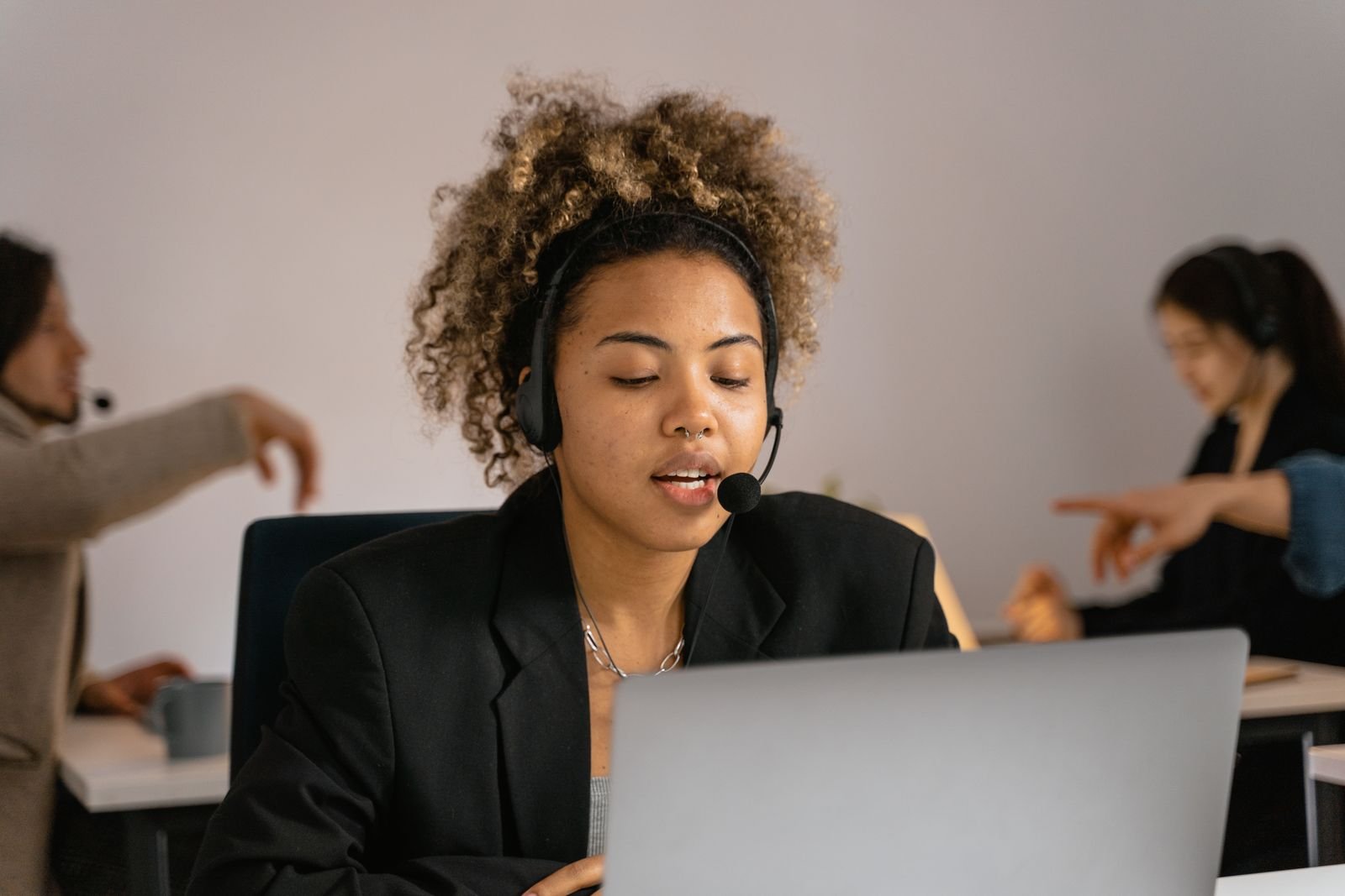 A support specialist with a headset working on a laptop