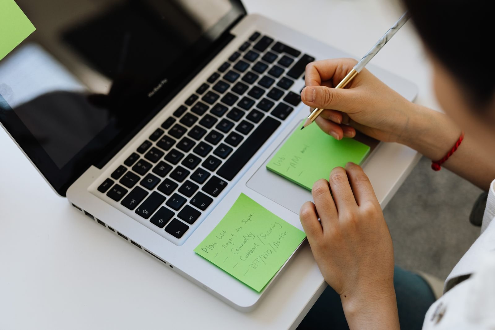 Notes on sticky pads next to a laptop