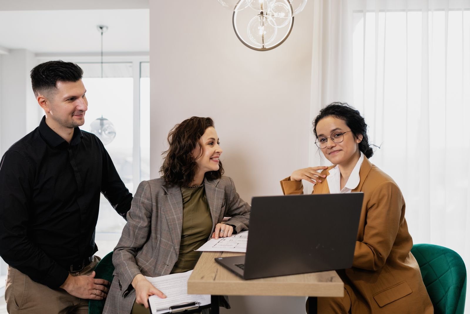 An agency team meeting around a laptop